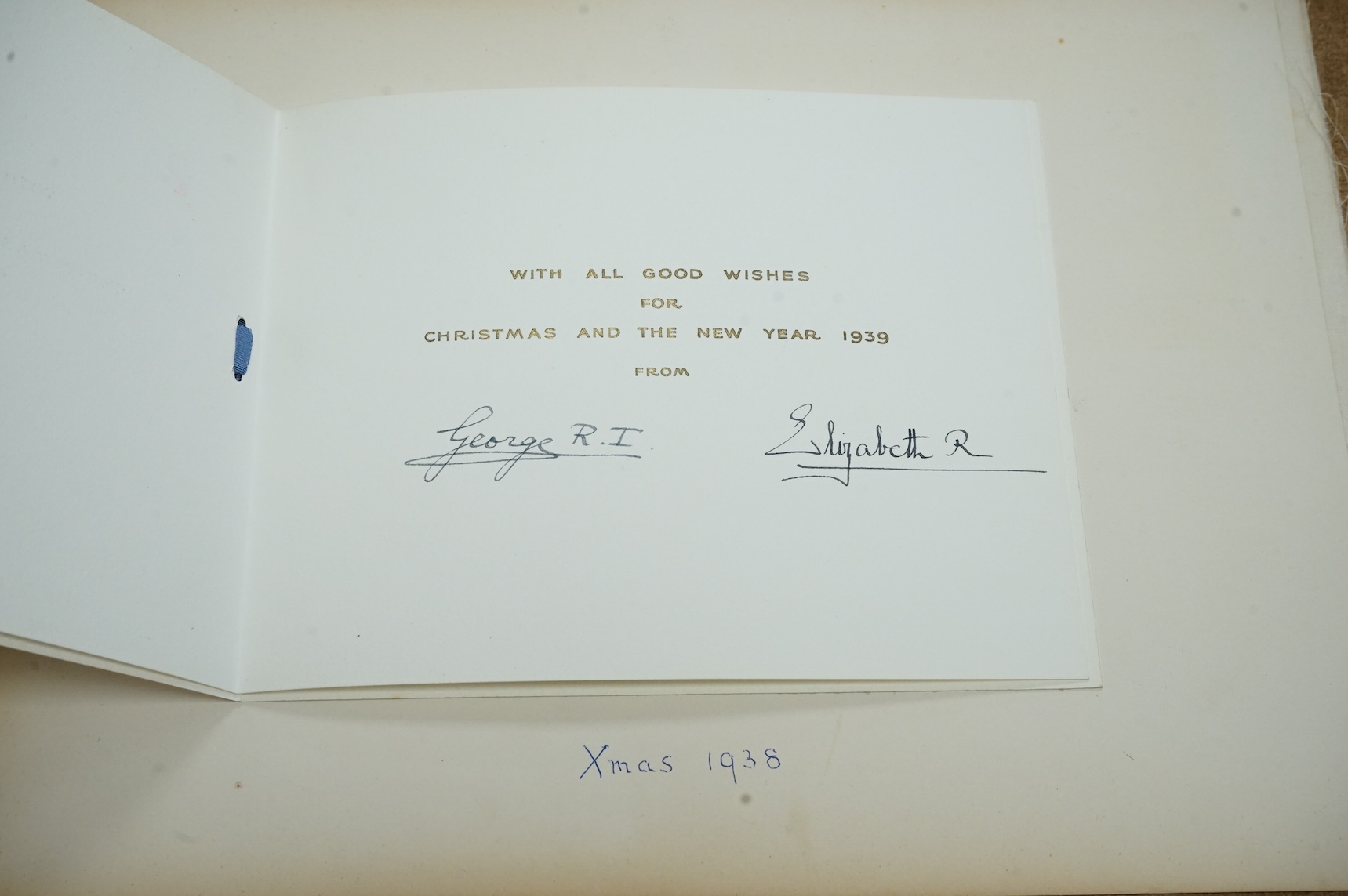 HRH King George VI and Queen Elizabeth signed Christmas card for 1938, with a colour photograph of the garden at Balmoral Castle entitled ‘Balmoral 1938’ to the cover, pasted onto a card leaf from a photograph/scrap albu